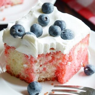 This is the ultimate summer cake! White sheet cake soaked through with strawberry Jell-O, and smothered in Cool Whip. No bake perfection :)